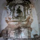 Entriamo prima nella cappella, che originariamente era arricchita da un dipinto della Madonna di cui oggi non resta che la cornice in gesso